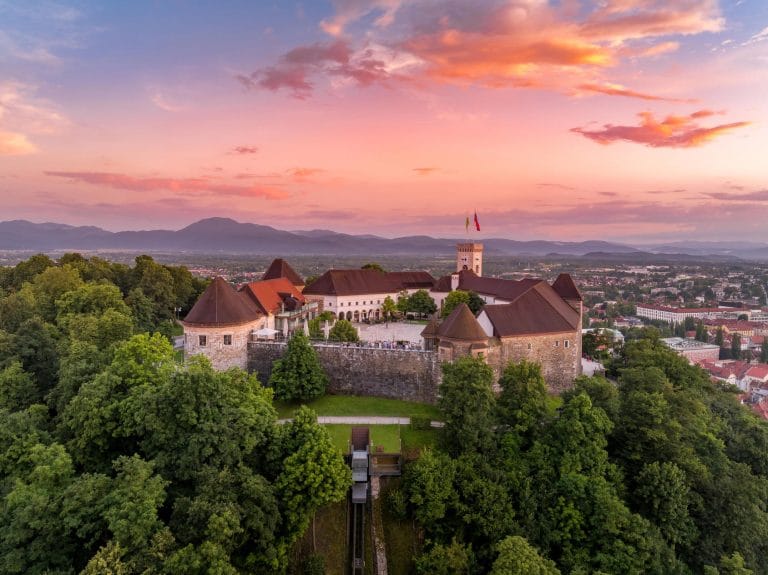 Ljubljana Castle above the city at sunset with hills in the distance