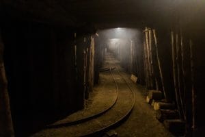 Dark underground tunnel with rails inside Idrija Mercury Mine