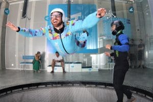 Smiling visitor flying with an instructor at Aerodium Logatec