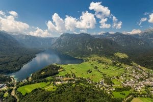 Wide aerial view of Lake Bohinj, Bohinj villages and the surrounding Julian Alps.
