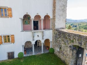 Two stacked three-arched arcades, the upper one with painted walls, in the inner courtyard at Prem Castle.