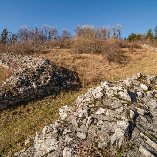 Preserved Roman fort walls climbing a sunny hillside at Ad Pirum.